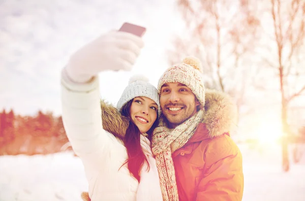 Casal feliz tomando selfie por smartphone no inverno — Fotografia de Stock