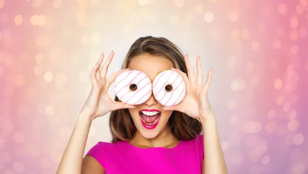 Glückliche Frau oder Teenie-Mädchen, die durch Donuts schauen — Stockfoto