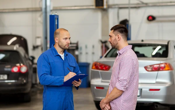 Auto monteur met klembord en man bij de auto-shop — Stockfoto