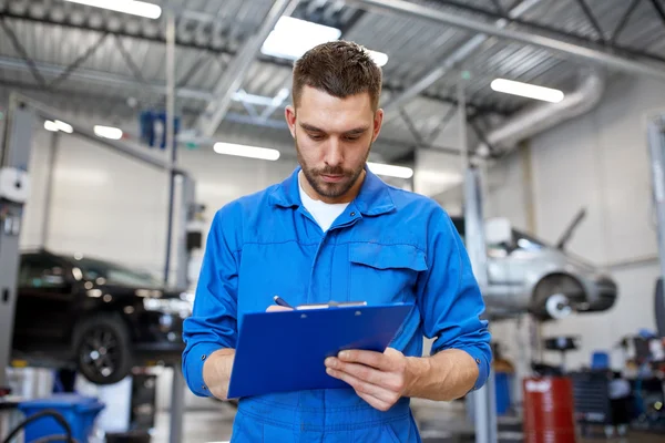Auto mechanic man with clipboard at car workshop — Stock Photo, Image