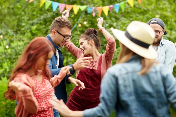Счастливые друзья танцуют на летней вечеринке в саду — стоковое фото