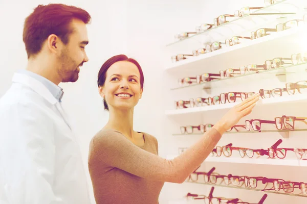 Mulher mostrando óculos para o óptico na loja de óptica — Fotografia de Stock