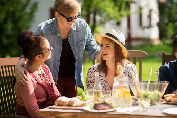 Happy friends having dinner at summer garden party — Stock Photo, Image