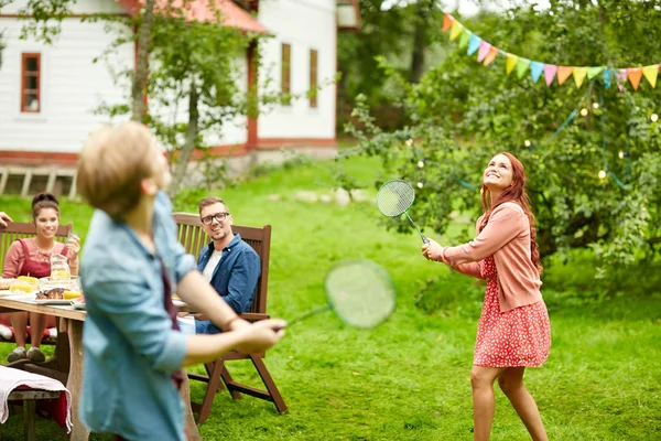 Glada vänner spelar badminton på sommaren trädgård — Stockfoto