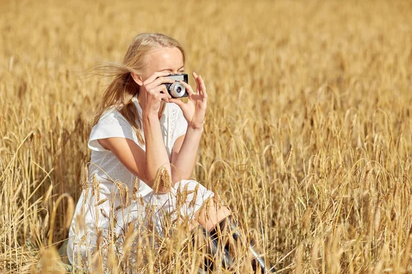 Женщина фотографируется с камерой в зерновом поле — стоковое фото