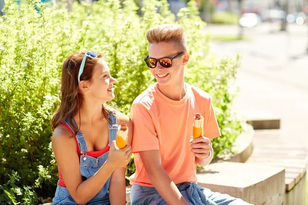 Gelukkige tiener paar hotdogs eten in de stad — Stockfoto