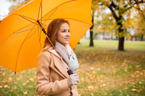 秋の公園を歩く傘を持つ幸せな女性 — ストック写真