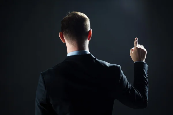 Hombre de negocios señalando con el dedo algo invisible — Foto de Stock