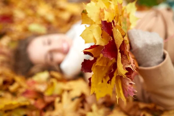 Primo piano di donna felice sdraiata su foglie di autunno — Foto Stock