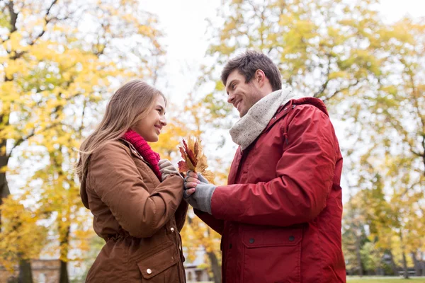 Šťastný pár s maple listy na podzim park — Stock fotografie
