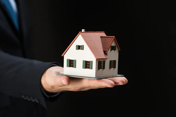 Close up of businessman hand holding house model — Stock Photo, Image