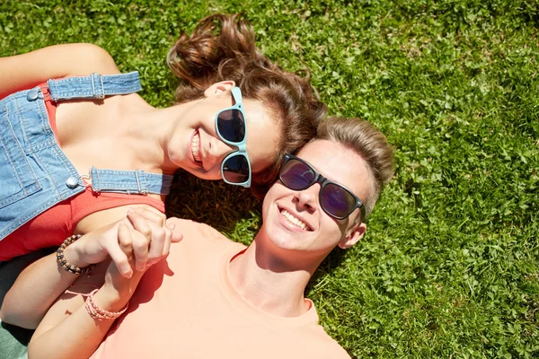Feliz pareja adolescente acostada en la hierba en verano —  Fotos de Stock