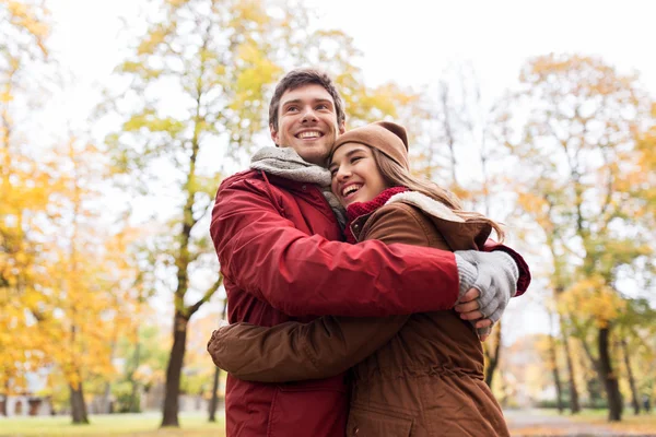 Feliz jovem casal abraçando no parque de outono — Fotografia de Stock