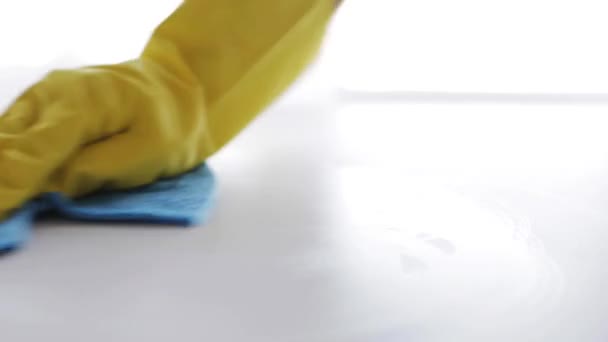 Hand in een rubber handschoen met doek schoonmaken van tabel — Stockvideo