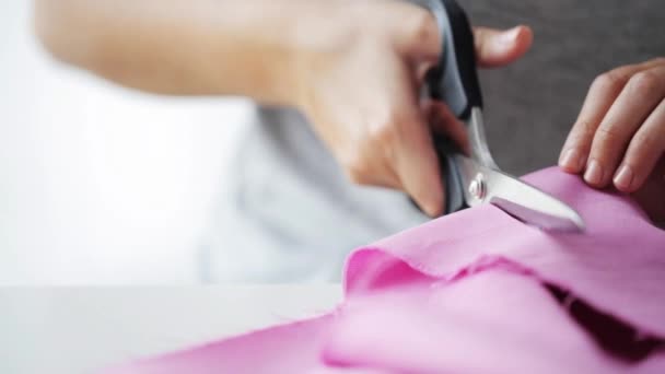 Woman with tailor scissors cutting out fabric — Stock Video