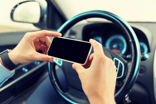 Close up of man hand with smartphone driving car — Stock Photo, Image