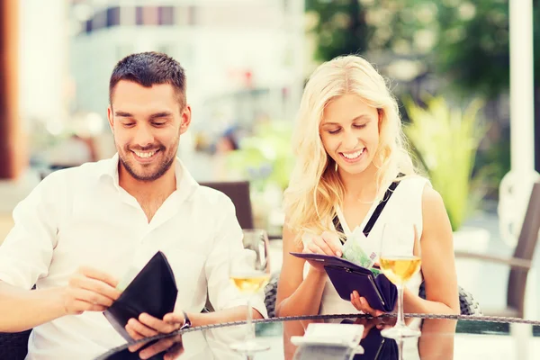 Szczęśliwa para z portfela płacąc rachunek w restauracji — Zdjęcie stockowe
