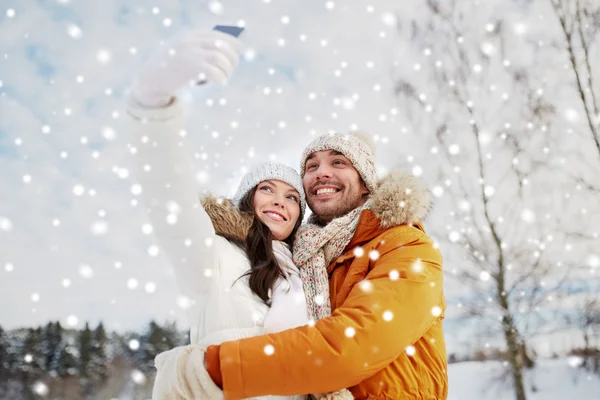 Casal feliz tomando selfie por smartphone no inverno — Fotografia de Stock
