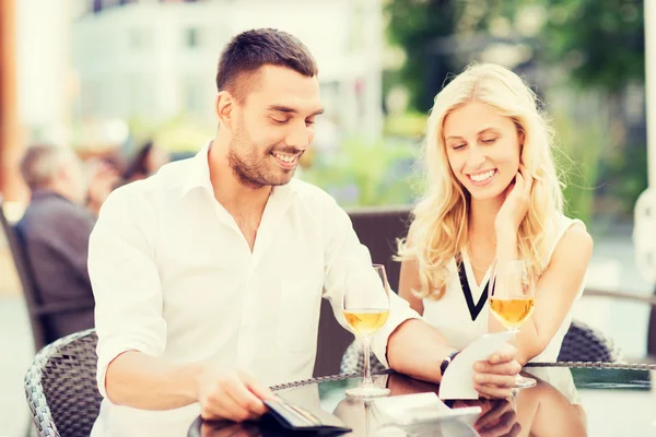 Casal feliz com carteira e conta no restaurante — Fotografia de Stock