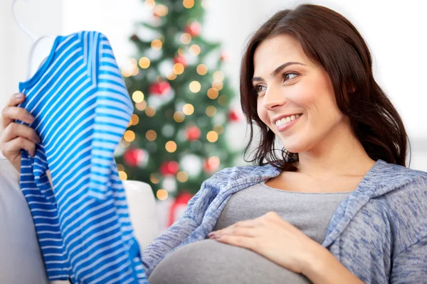 Happy woman holding baby boys bodysuit at home — Stock Photo, Image