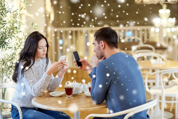 Couple with smartphones drinking tea at cafe — Stock Photo, Image