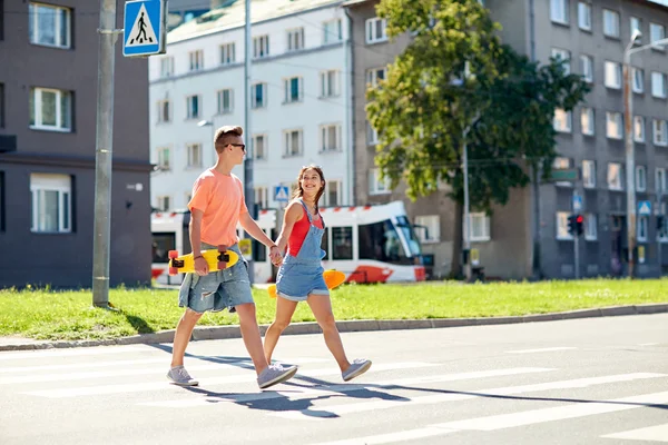 Casal adolescente com skates na rua da cidade — Fotografia de Stock