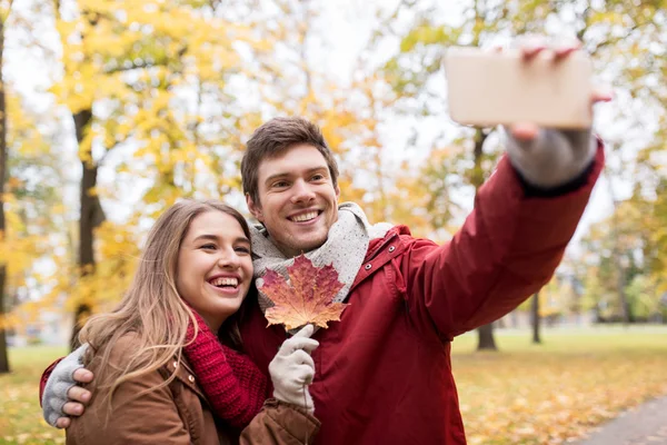 Pareja tomando selfie por smartphone en el parque de otoño — Foto de Stock