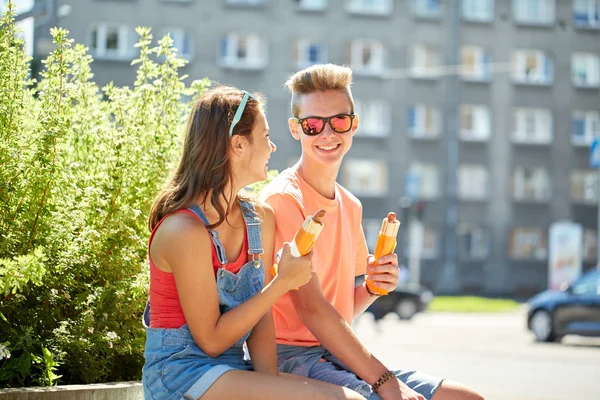 Happy teenage couple eating hot dogs in city — Stock Photo, Image