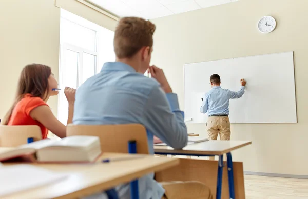 Öğrenciler ve okul üzerinde yazma öğretmen kurulu beyaz — Stok fotoğraf