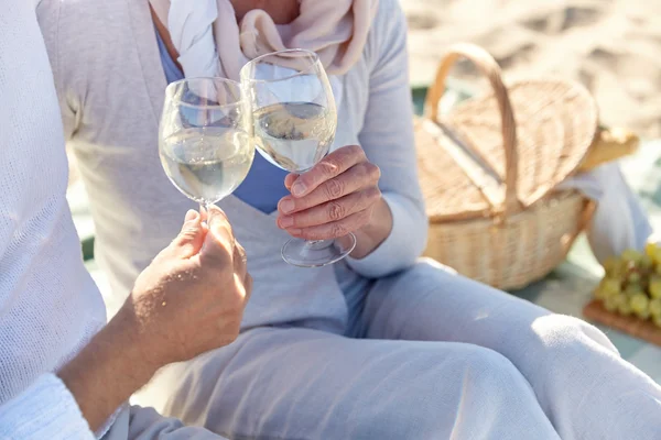 Happy senior couple having picnic on summer beach — Stock Photo, Image