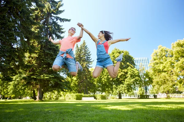 Felice coppia di adolescenti saltando al parco estivo — Foto Stock