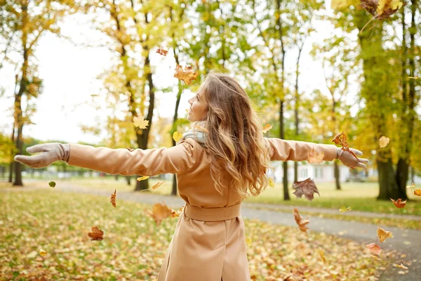 가을 공원에서 나뭇잎으로 즐겁게 노는 행복 한 여인 — 스톡 사진