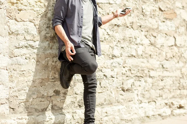 Чоловік з навушниками та смартфоном на вулиці — стокове фото