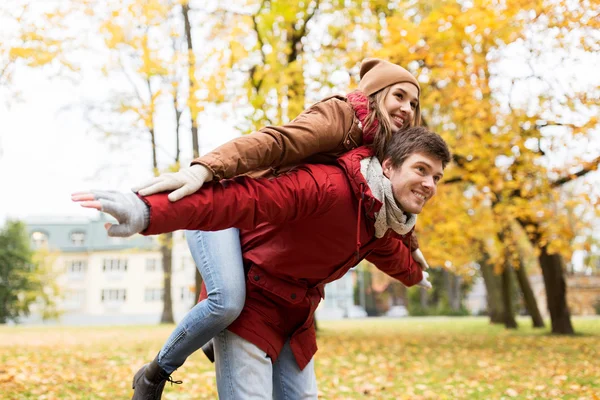 Feliz pareja joven divirtiéndose en el parque de otoño — Foto de Stock