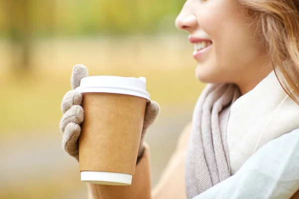 Close up of happy woman with coffee in autumn park — Stock Photo, Image