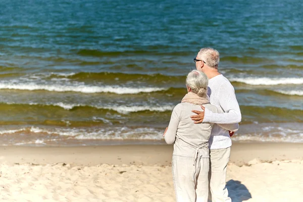 Happy senior couple hugging on summer beach — Stock Photo, Image
