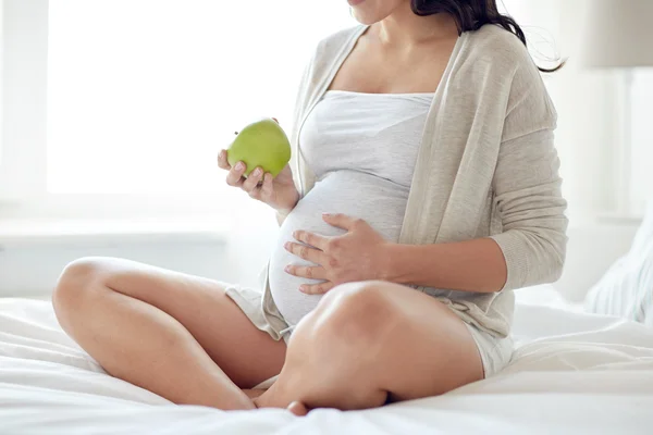 Zamknij się kobieta w ciąży jedzenia jabłek w domu — Zdjęcie stockowe