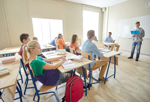 Estudiante con cuaderno y profesor en la escuela — Foto de Stock