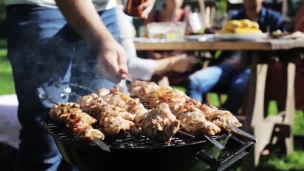 Счастливые друзья на вечеринке барбекю в летнем саду — стоковое видео