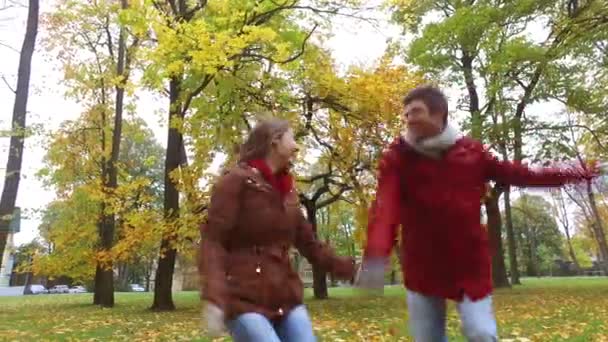 Happy νεαρό ζευγάρι τη διασκέδαση στο πάρκο φθινόπωρο — Αρχείο Βίντεο