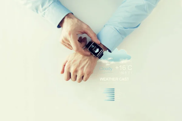 Mãos com aplicativo de previsão do tempo no relógio inteligente — Fotografia de Stock