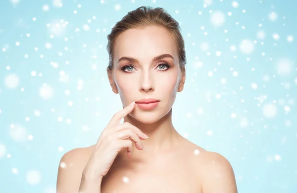 Bella giovane donna mostrando le labbra sopra la neve — Foto Stock