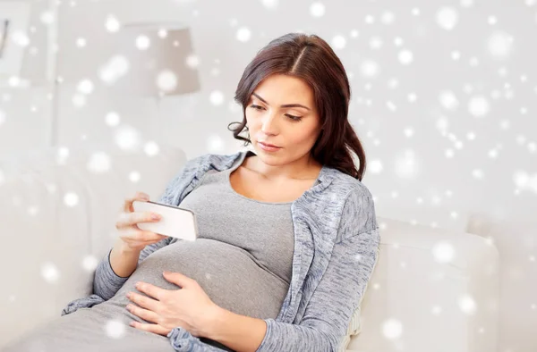 Smutne, Kobieta w ciąży z smartphone w domu — Zdjęcie stockowe