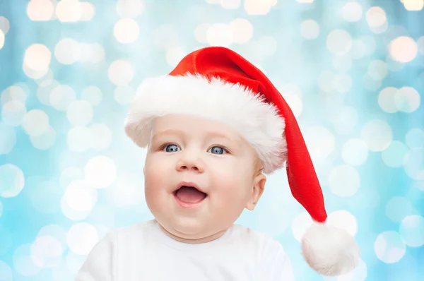 Menino no Natal chapéu de Papai Noel sobre luzes azuis — Fotografia de Stock