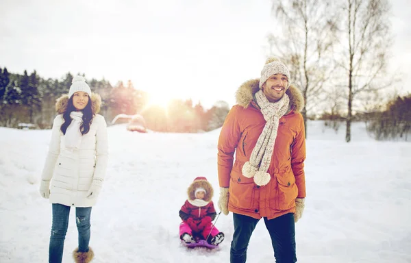 幸福的家庭，与雪橇行走在冬天的户外 — 图库照片