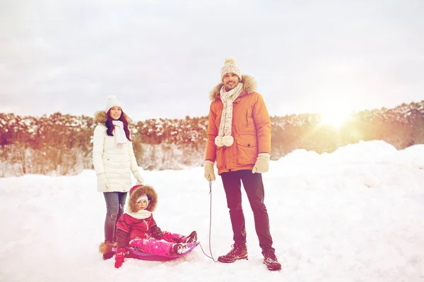 Счастливая семья с санями ходить зимой на открытом воздухе — стоковое фото