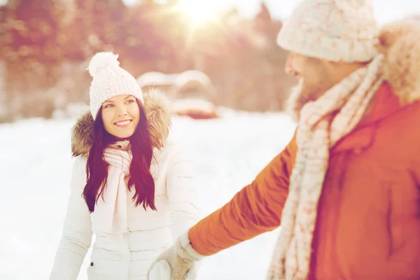 Gelukkige paar wandelen langs besneeuwde winter veld — Stockfoto