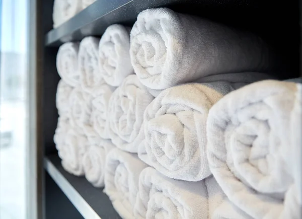 Toallas de baño blancas enrolladas en el spa del hotel — Foto de Stock