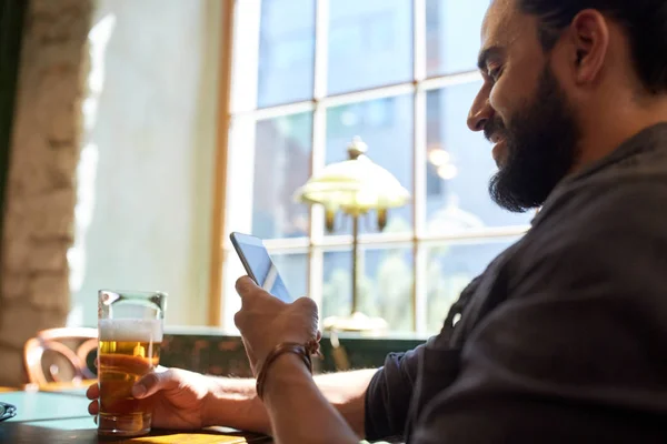 Primer plano del hombre con smartphone y cerveza en el pub — Foto de Stock