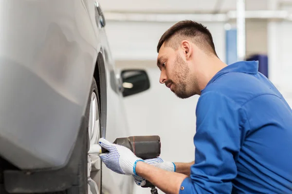 Mecánico con destornillador cambio de neumáticos de coche —  Fotos de Stock